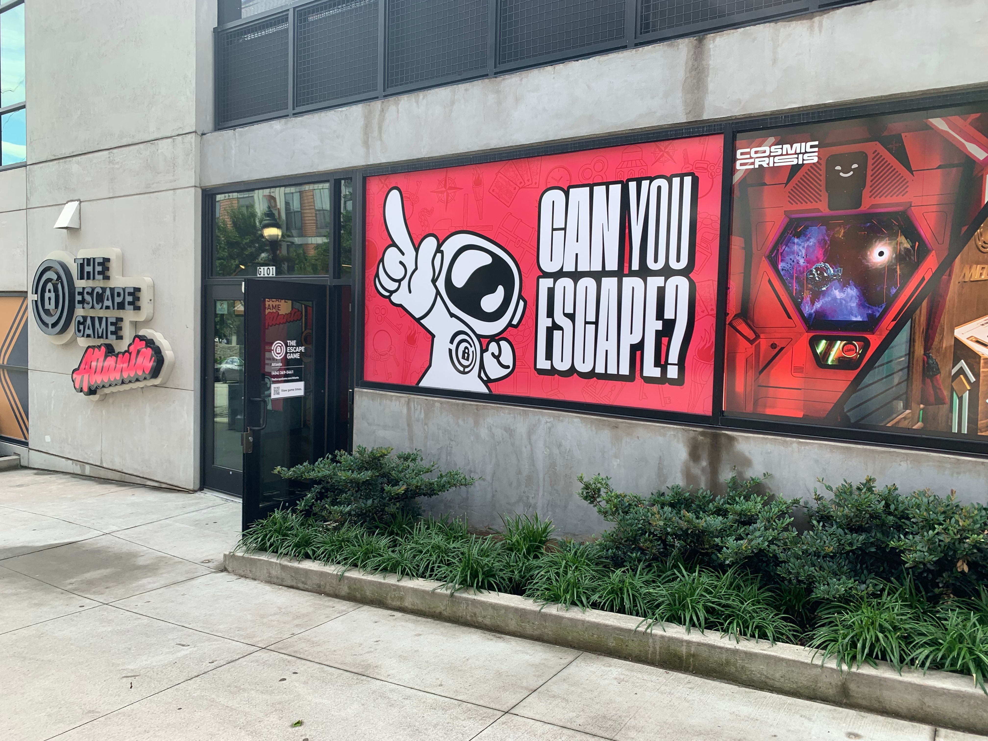 Exterior of The Escape Game Atlanta, featuring a large colorful banner that reads "CAN YOU ESCAPE?" and a cartoon astronaut.