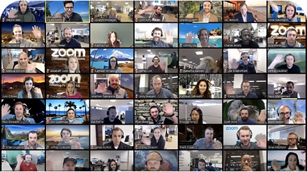 A grid of multiple people in a video call, all waving, with various backgrounds including office spaces and scenic views.
