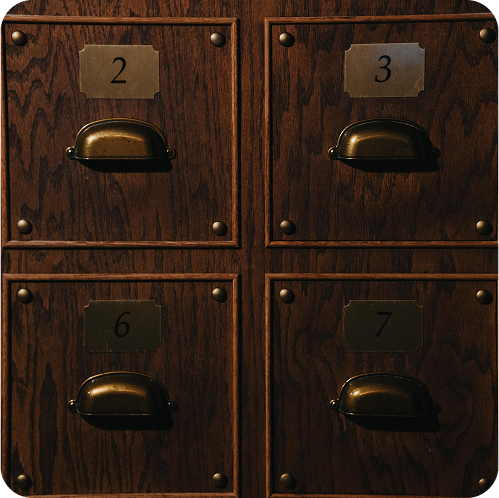 Close-up of a wooden cabinet with four labeled drawers, numbered 2, 3, 6, and 7, each with a brass handle.