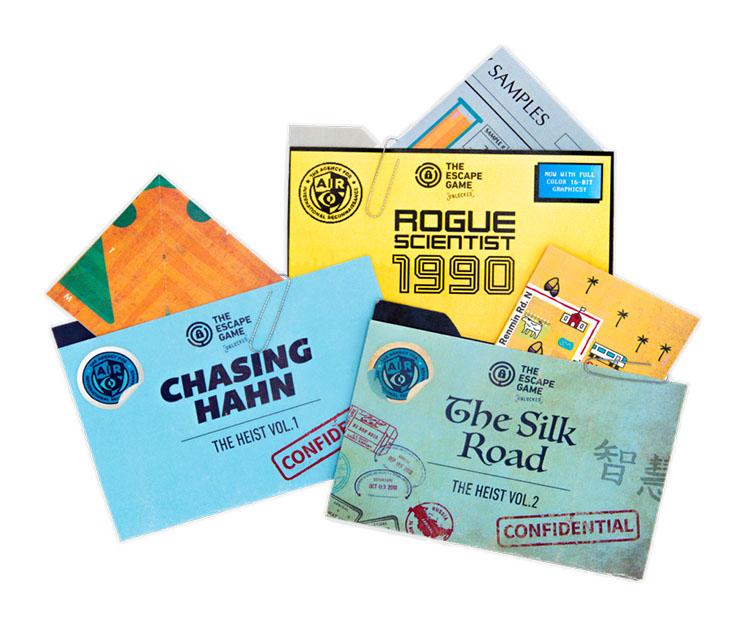 A collection of colorful game envelopes, including titles like "Chasing Hahn," "Rogue Scientist 1990," and "The Silk Road."
