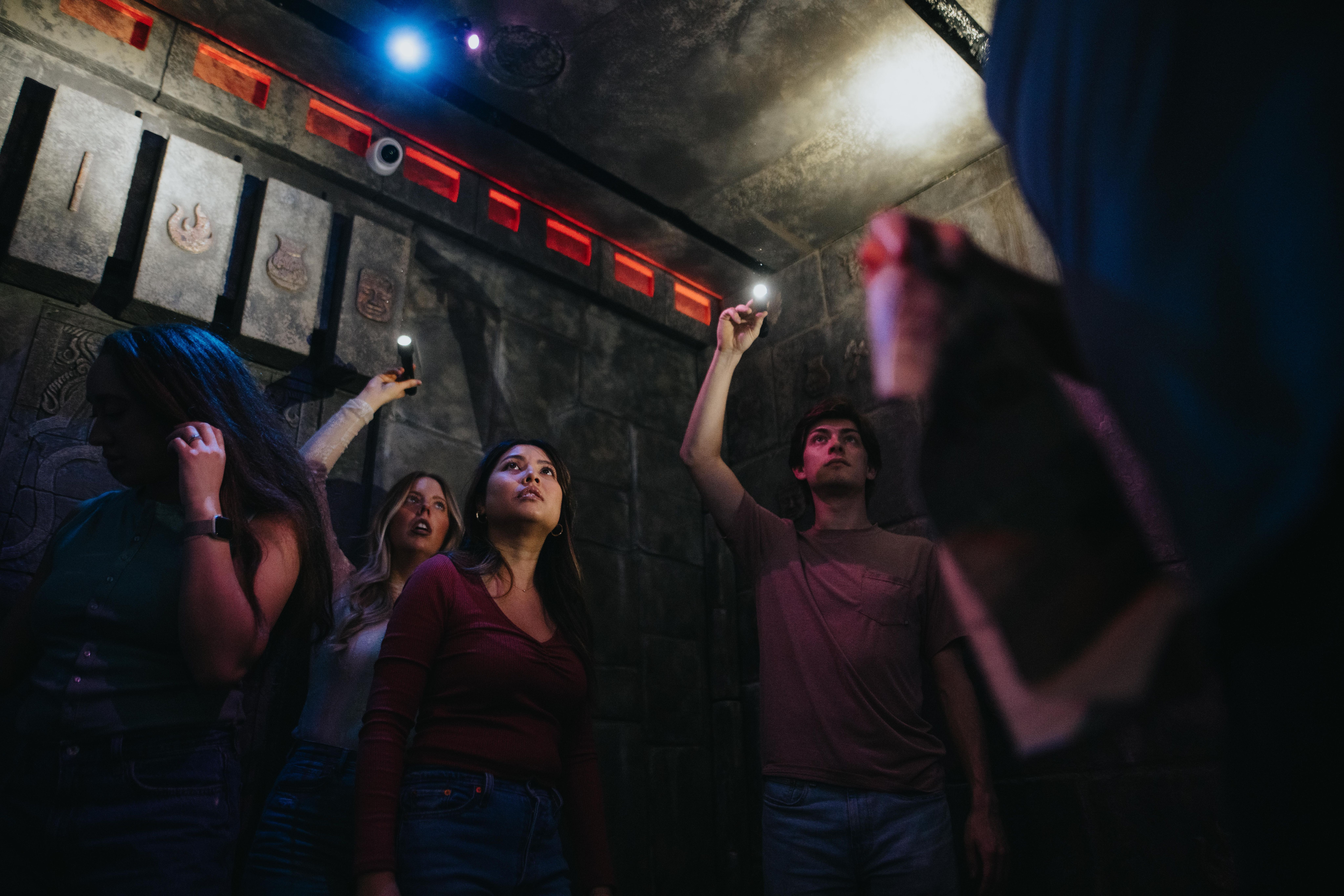 Group shining flashlights in an escape room