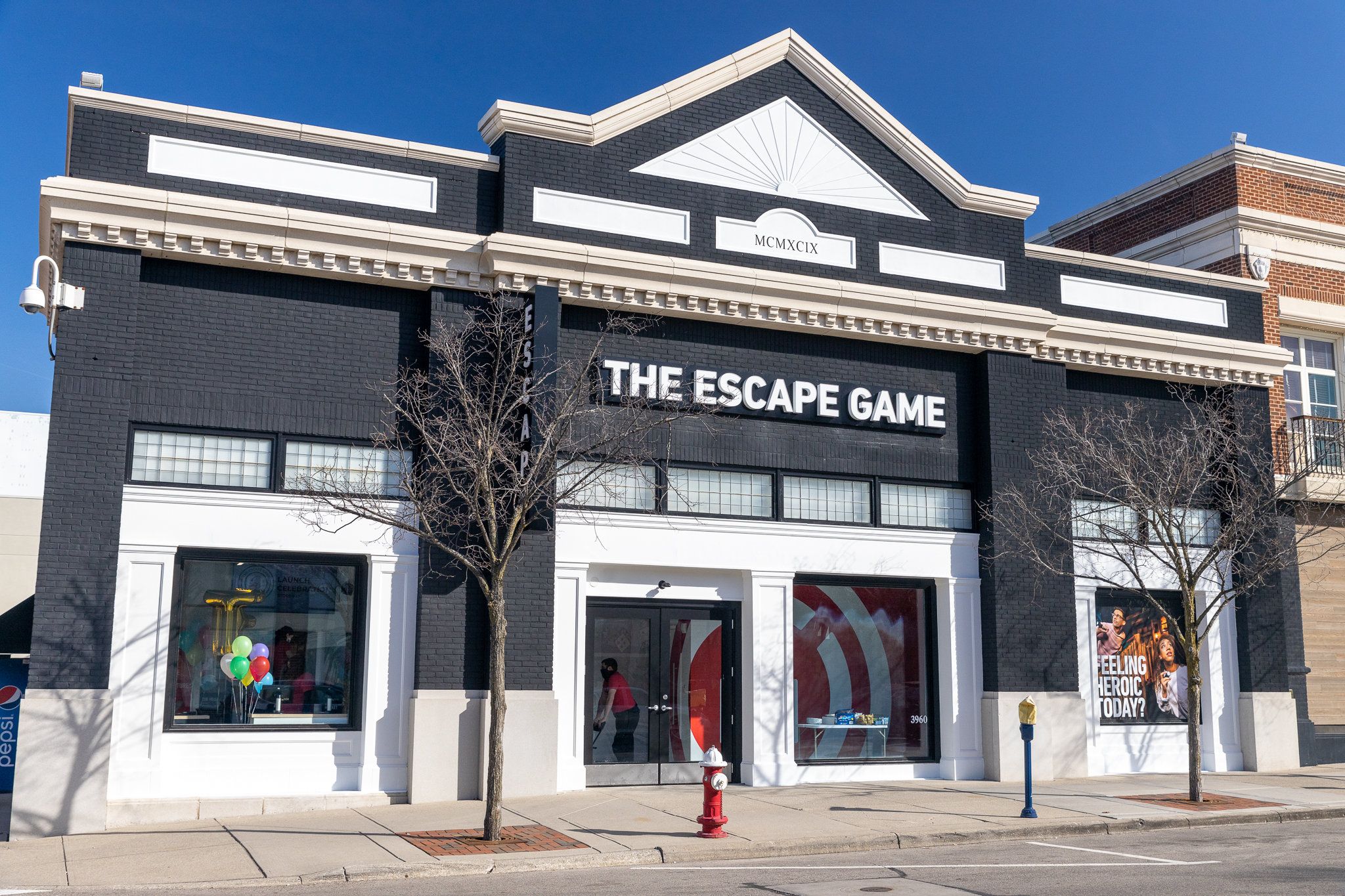 Front view of "The Escape Game" building, featuring a black facade, large windows, and decorative architecture.