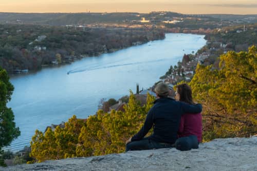 a couple watching a sunset on Mount Bonnell