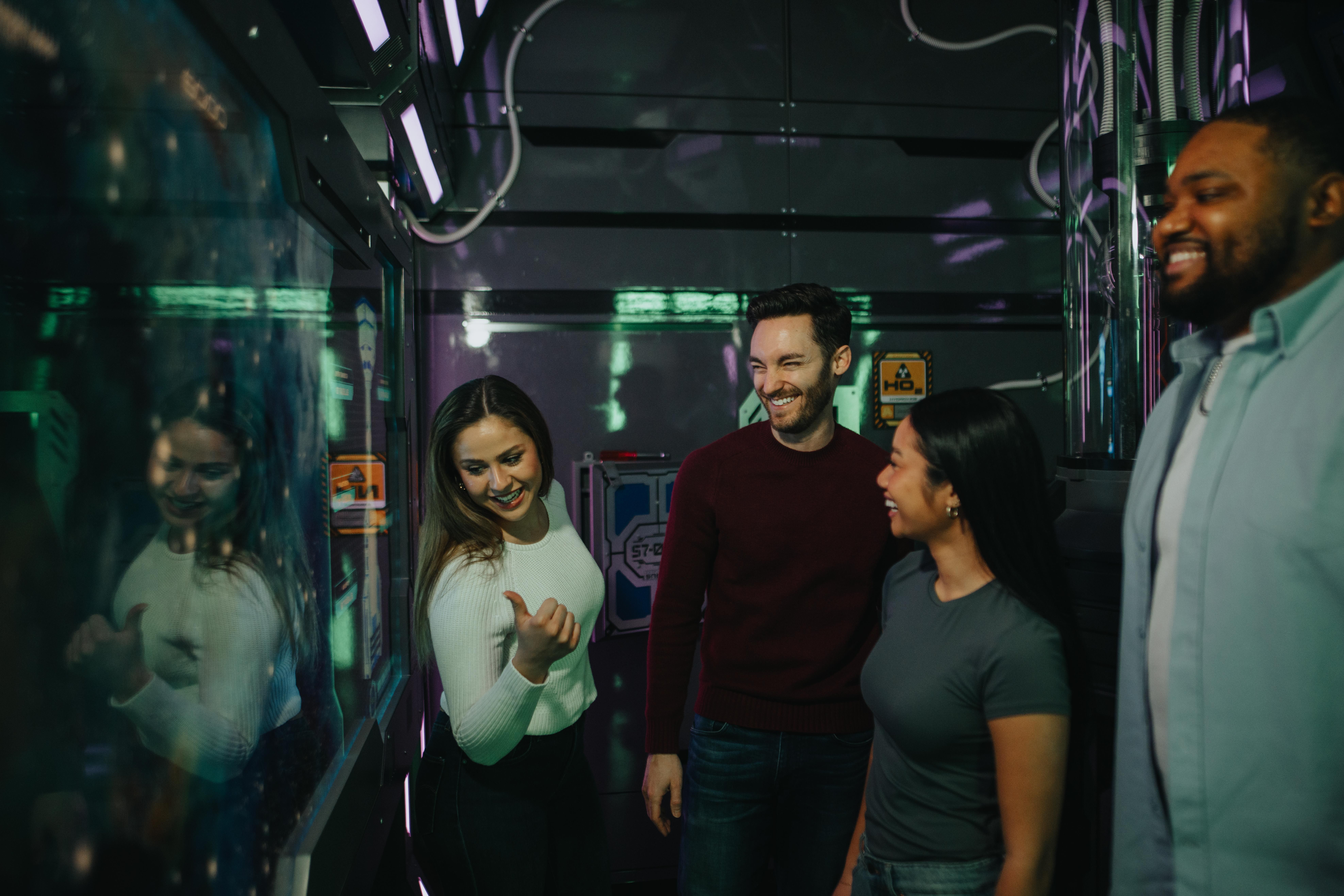 Four people smiling in an escape room