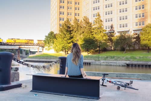 a woman sitting next to a river 
