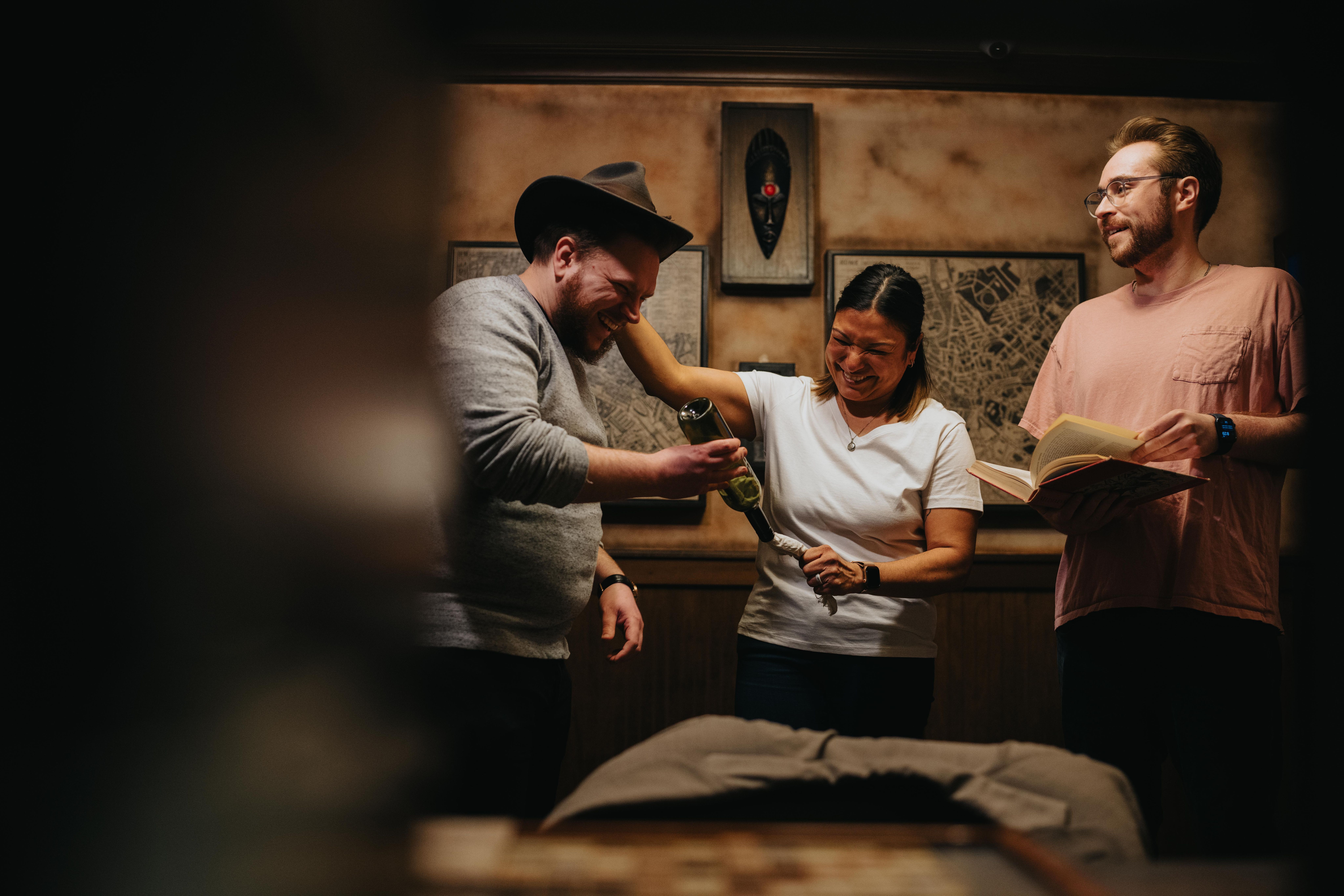 Three people smiling an escape room