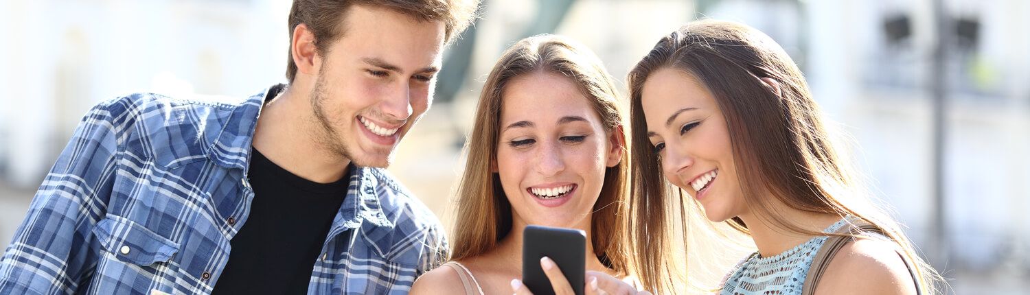 three people looking at a phone